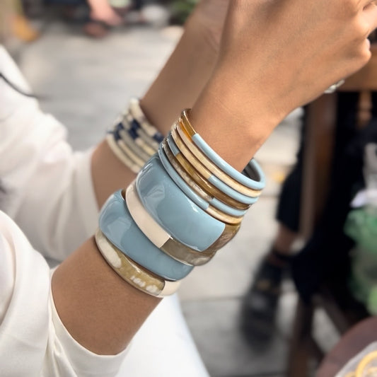 Ajoutez une touche d'élégance à votre collection de bijoux avec le sublime jonc laqué en corne naturelle "Chacha d'Amour". Ce bracelet unique, d'une délicate teinte BLEU CIEL, allie artisanat traditionnel et modernité, offrant une pièce d'exception pour toutes les occasions. Fabriqué à partir de corne 100% naturelle, chaque jonc est soigneusement travaillé à la main, garantissant ainsi un design original et authentique. Que ce soit pour un look quotidien ou une occasion spéciale, le jonc "Chacha d'Amour" 