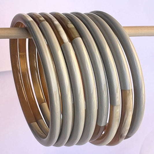 Découvrez le jonc laqué en corne naturelle "Chacha d'Amour", une pièce unique qui allie artisanat et mode. Ce bracelet, avec sa magnifique teinte gris, est fabriqué à partir de corne 100 % naturelle, ce qui lui confère à la fois légèreté et durabilité. Chaque jonc est soigneusement confectionné à la main, garantissant que vous portez un bijou authentique et original.

